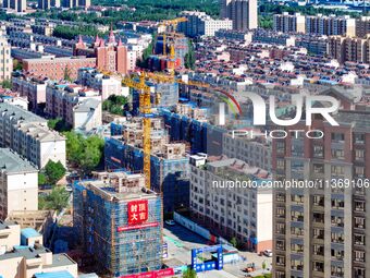 Builders are working at the construction site of a house renovation project in Baotou, Inner Mongolia, China, on June 29, 2024. (