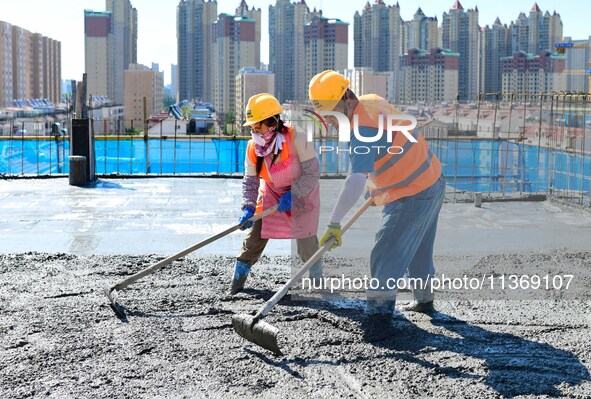 Builders are working at the construction site of a house renovation project in Baotou, Inner Mongolia, China, on June 29, 2024. 