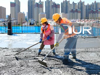 Builders are working at the construction site of a house renovation project in Baotou, Inner Mongolia, China, on June 29, 2024. (