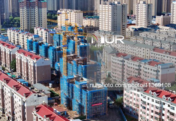 Builders are working at the construction site of a house renovation project in Baotou, Inner Mongolia, China, on June 29, 2024. 