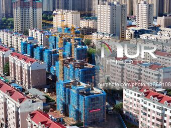 Builders are working at the construction site of a house renovation project in Baotou, Inner Mongolia, China, on June 29, 2024. (