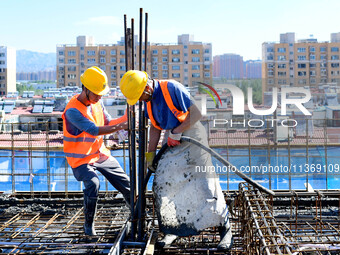 Builders are working at the construction site of a house renovation project in Baotou, Inner Mongolia, China, on June 29, 2024. (