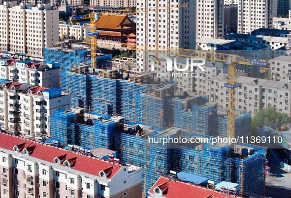 Builders are working at the construction site of a house renovation project in Baotou, Inner Mongolia, China, on June 29, 2024. 