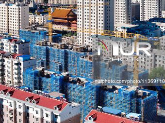 Builders are working at the construction site of a house renovation project in Baotou, Inner Mongolia, China, on June 29, 2024. (