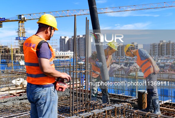 Builders are working at the construction site of a house renovation project in Baotou, Inner Mongolia, China, on June 29, 2024. 