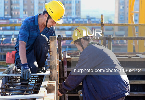 Builders are working at the construction site of a house renovation project in Baotou, Inner Mongolia, China, on June 29, 2024. 