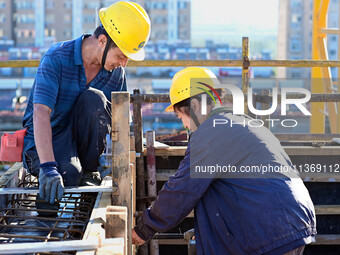 Builders are working at the construction site of a house renovation project in Baotou, Inner Mongolia, China, on June 29, 2024. (