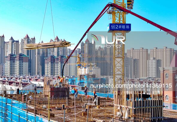 Builders are working at the construction site of a house renovation project in Baotou, Inner Mongolia, China, on June 29, 2024. 