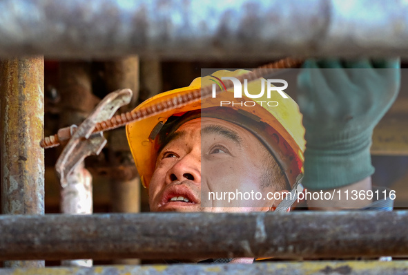 Builders are working at the construction site of a house renovation project in Baotou, Inner Mongolia, China, on June 29, 2024. 