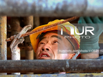 Builders are working at the construction site of a house renovation project in Baotou, Inner Mongolia, China, on June 29, 2024. (