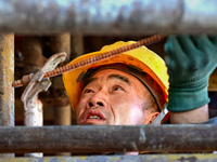 Builders are working at the construction site of a house renovation project in Baotou, Inner Mongolia, China, on June 29, 2024. (