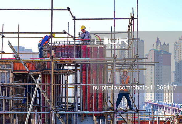 Builders are working at the construction site of a house renovation project in Baotou, Inner Mongolia, China, on June 29, 2024. 