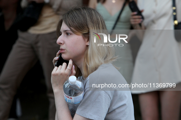 A woman is making a phone call during a search and rescue effort at an apartment block hit by a Russian missile in Dnipro, Ukraine, on June...