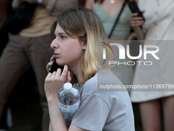 A woman is making a phone call during a search and rescue effort at an apartment block hit by a Russian missile in Dnipro, Ukraine, on June...