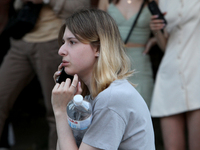 A woman is making a phone call during a search and rescue effort at an apartment block hit by a Russian missile in Dnipro, Ukraine, on June...