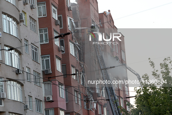 A firefighter in an aerial work platform is putting out a fire during a search and rescue effort at the apartment block hit by the Russian m...