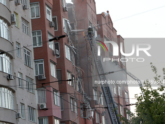 A firefighter in an aerial work platform is putting out a fire during a search and rescue effort at the apartment block hit by the Russian m...