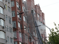 A firefighter in an aerial work platform is putting out a fire during a search and rescue effort at the apartment block hit by the Russian m...