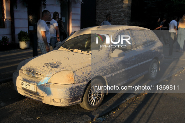 Dust is covering a car during a search and rescue effort at an apartment block hit by a Russian missile in Dnipro, Ukraine, on June 28, 2024...