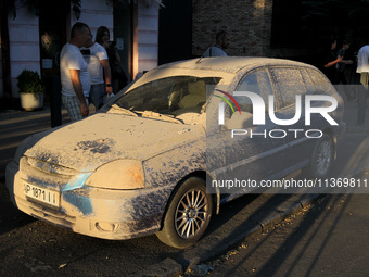 Dust is covering a car during a search and rescue effort at an apartment block hit by a Russian missile in Dnipro, Ukraine, on June 28, 2024...