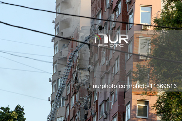 A firefighter in an aerial work platform is carrying out a search and rescue effort at the apartment block hit by the Russian missile in Dni...