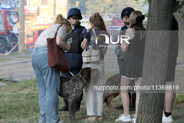 Rescuers are staying by people outside an apartment block hit by a Russian missile in Dnipro, Ukraine, on June 28, 2024. Russian troops are...