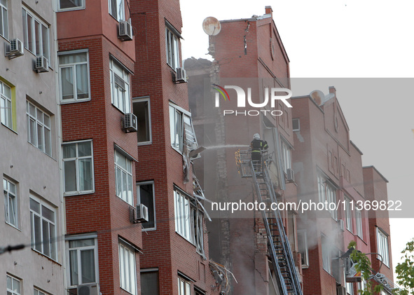 A firefighter in an aerial work platform is putting out a fire during a search and rescue effort at the apartment block hit by the Russian m...