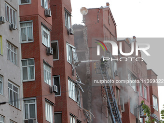 A firefighter in an aerial work platform is putting out a fire during a search and rescue effort at the apartment block hit by the Russian m...