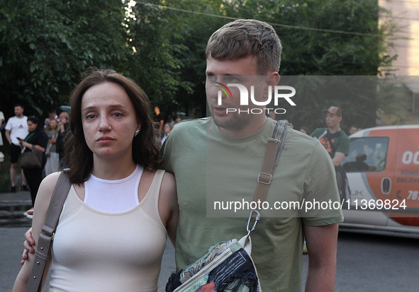 A man and woman are participating in a search and rescue effort at an apartment block hit by a Russian missile in Dnipro, Ukraine, on June 2...