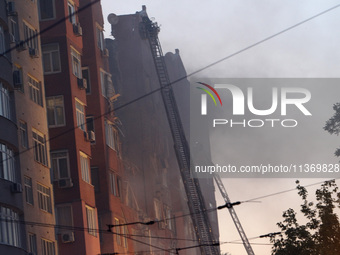 Firefighters in aerial work platforms are carrying out a search and rescue effort at an apartment block hit by a Russian missile in Dnipro,...