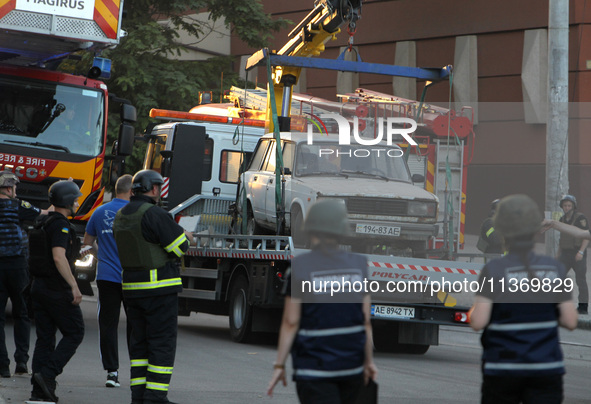 A car is being towed away during a search and rescue effort at an apartment block hit by a Russian missile in Dnipro, Ukraine, on June 28, 2...