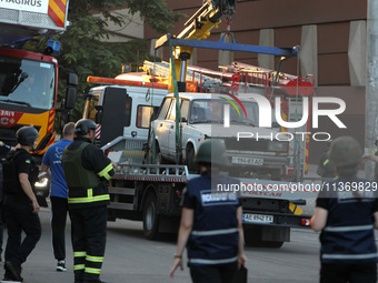 A car is being towed away during a search and rescue effort at an apartment block hit by a Russian missile in Dnipro, Ukraine, on June 28, 2...