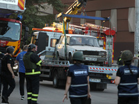 A car is being towed away during a search and rescue effort at an apartment block hit by a Russian missile in Dnipro, Ukraine, on June 28, 2...