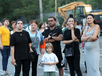 Onlookers are watching a search and rescue effort at an apartment block hit by a Russian missile in Dnipro, Ukraine, on June 28, 2024. Russi...