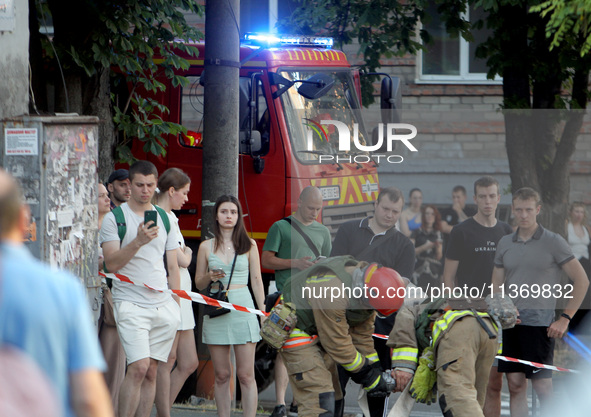 Onlookers are watching a search and rescue effort at an apartment block hit by a Russian missile in Dnipro, Ukraine, on June 28, 2024. Russi...