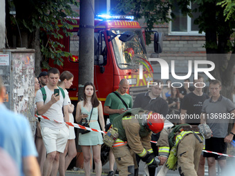 Onlookers are watching a search and rescue effort at an apartment block hit by a Russian missile in Dnipro, Ukraine, on June 28, 2024. Russi...