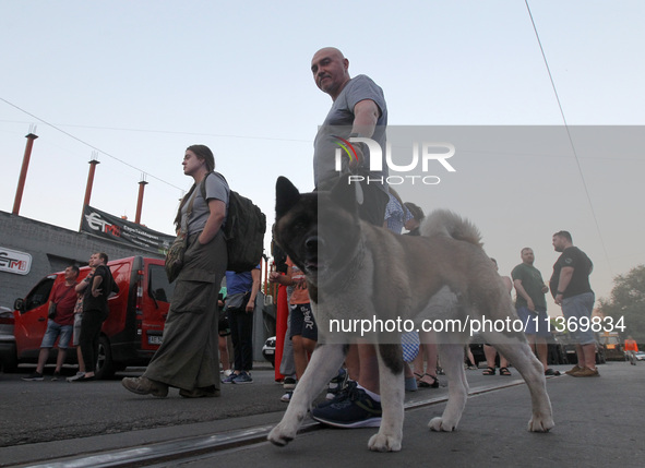 A man and a dog are participating in a search and rescue effort at an apartment block hit by a Russian missile in Dnipro, Ukraine, on June 2...