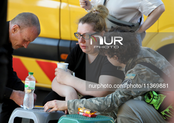 A woman affected by the June 28 Russian missile attack on the apartment block is receiving aid in Dnipro, Ukraine, on June 29, 2024. On Frid...