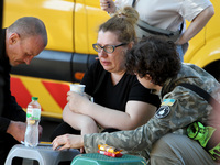 A woman affected by the June 28 Russian missile attack on the apartment block is receiving aid in Dnipro, Ukraine, on June 29, 2024. On Frid...