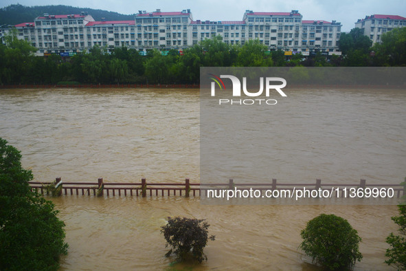 Part of the walking path is flooding as the water level of Yaqian River is rising due to heavy rainfall in Anqing, China, on June 29, 2024. 