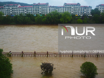 Part of the walking path is flooding as the water level of Yaqian River is rising due to heavy rainfall in Anqing, China, on June 29, 2024....