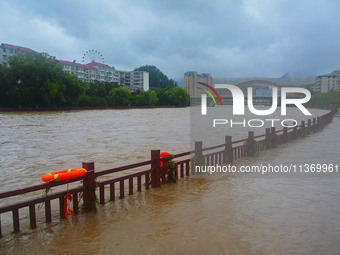 Part of the walking path is flooding as the water level of Yaqian River is rising due to heavy rainfall in Anqing, China, on June 29, 2024....