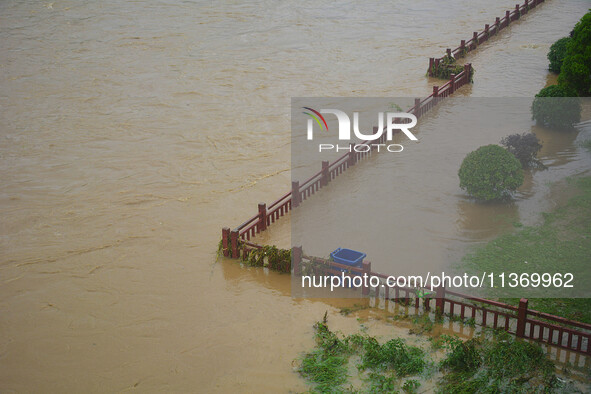 Part of the walking path is flooding as the water level of Yaqian River is rising due to heavy rainfall in Anqing, China, on June 29, 2024. 