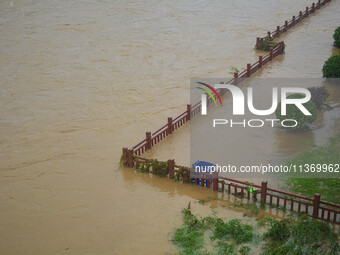 Part of the walking path is flooding as the water level of Yaqian River is rising due to heavy rainfall in Anqing, China, on June 29, 2024....