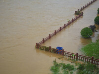 Part of the walking path is flooding as the water level of Yaqian River is rising due to heavy rainfall in Anqing, China, on June 29, 2024....