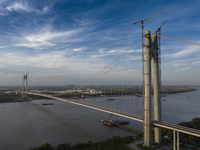 An aerial photo is showing ships passing under the Xianxin Road Yangtze River Bridge under construction in Nanjing, China, on June 29, 2024....