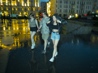 Young people are seen walking during a downpour in Warsaw, Poland on 28 June, 2024. (