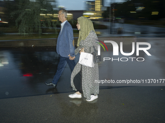 A man and a woman with a hedscarf are seen holding hands in Warsaw, Poland on 28 June, 2024. (