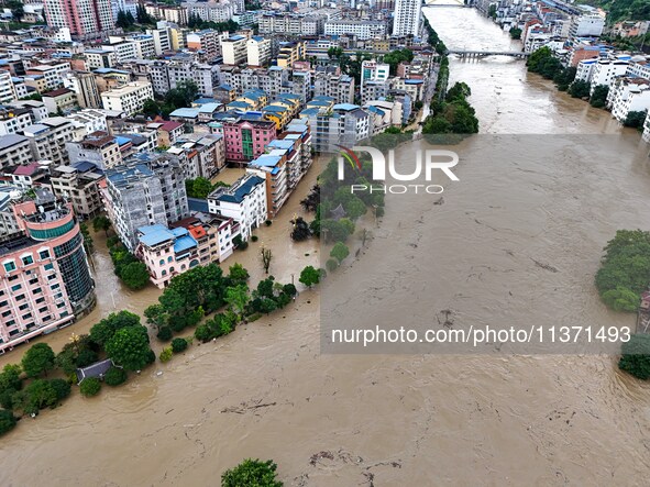 Aerial photo is showing houses and fields along the Wuyang River's Cenggong and Zhenyuan Yangping sections being flooded in Qiandongnan Pref...