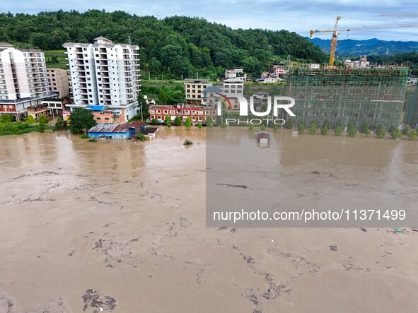 Aerial photo is showing houses and fields along the Wuyang River's Cenggong and Zhenyuan Yangping sections being flooded in Qiandongnan Pref...